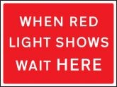 When red light shows wait here road sign